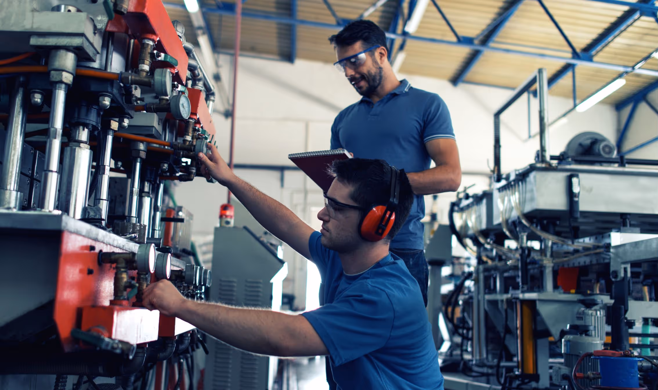 Two team members working on factory equipment