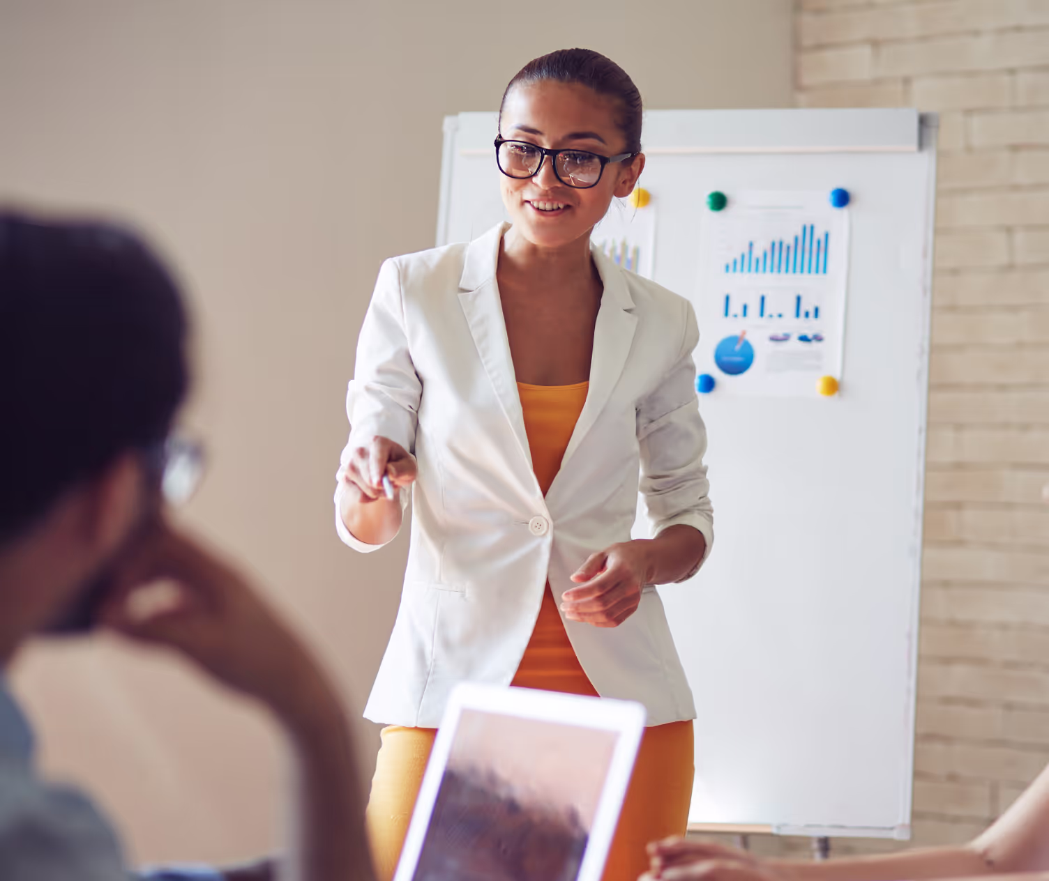 A leader presenting to her team at a whiteboard